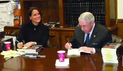 Bruce Baronâ€™s wife, Julie Baron, assists DA Hynes with Tuesdayâ€™s afternoonâ€™s book-signing. Photos courtesy of Baron Associates P.C.
