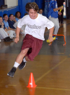 Eighth-grader Mike Rossetti runs around an obstacle during a relay race.