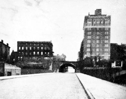 The Montague Street cut, also known as Wall Street Ferry Hill, as seen from the docks in 1927 (above, right), originally provided commuters from Brooklyn with access to a Manhattan ferry connection. Above the arch at center is the outlook terrace, while the then new 2 Montague Terrace apartment building is at right, the Pierrepont Place mansions at left.	Photo from Yesterdays on Brooklyn Heights by James H. Callender