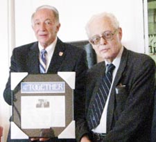 Dr. James Goldman, past vice-president of City Techâ€™s Faculty and Staff Association, presents an archival newspaper article to College President, Dr. Russell Hotzler.