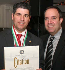 Outgoing president Dominic Famulari (left) is presented with a proclamation by Borough President Chief of Staff Carlo Scissura.
