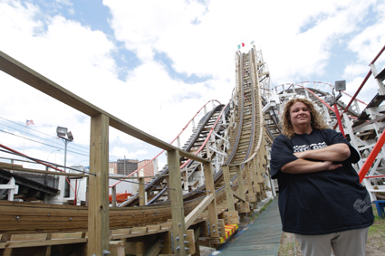 Jennifer Tortorici, the operations manager of the Cyclone roller coaster, poses with the octogenarian roller coaster on June 26. AP Photo/Mary Altaffer