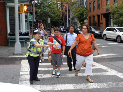 The crossing guard blows her whistle at an impatient driver as families try to cross the street. Eagle photo by Mary Frost