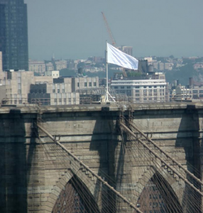 A white flag flies high atop the Brooklyn Bridge instead of American flags. Eagle photo by Mary Frost