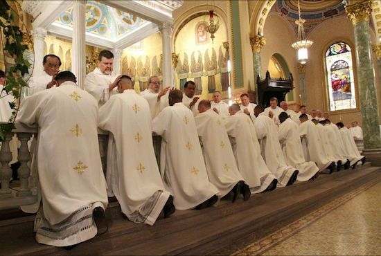 The priests of the Roman Catholic Diocese of Brooklyn each lay their hands on the heads of new priests during the ordination liturgy. Photo courtesy of the Roman Catholic Diocese of Brooklyn