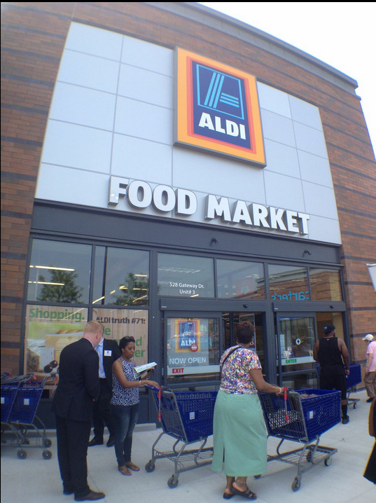 Aldi employees chat up customers outside the new super-discount supermarket.
