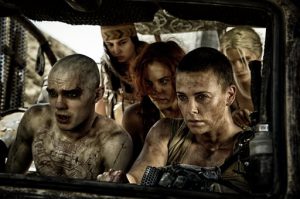 Charlize Theron (center) headlines the new upcoming "Mad Max" movie. It's also her birthday today.