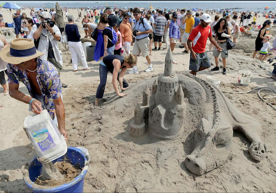 William Petrosino, left, mixes sand with water while carving a dragon and castle with Dartya Feklistova during a sand sculpting contest in Coney Island on Aug. 16. Proceeds from the contest will go toward helping residents still rebuilding from Superstorm Sandy. AP Photos/Julie Jacobson