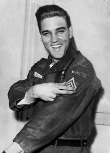 Elvis Presley smiles after he is promoted to army sergeant at the U.S. Army Unit's maneuver headquarters in Grafenwoehr, Germany, on Feb. 11, 1960. Presley went into the Army in 1958 and was shipped out for Europe at the Brooklyn Army Terminal. AP Photo