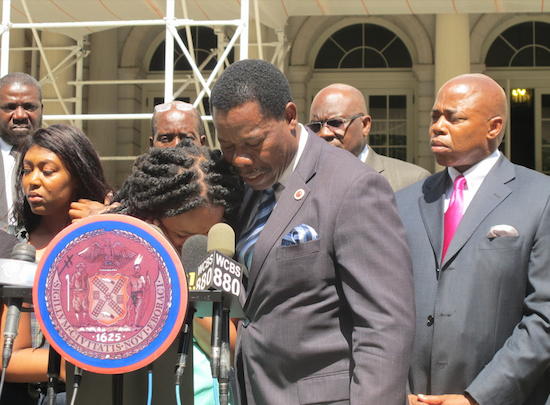 An emotional relative is embraced by Councilmember Mathieu Eugene.