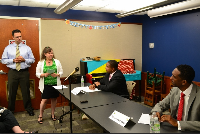 BID President Llamil Nunez looks on as BID Executive Director Renee Giordano reads a question from Sunset Parker member online for state senate candidates Jesse Hamilton (seated left) and Rubain Dorancy. Photo by Dylon Coyne