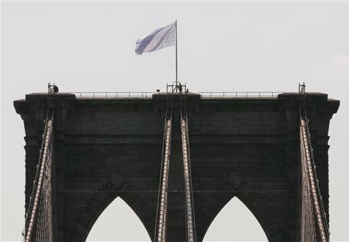 Two German artists have claimed responsibility for replacing the American flags atop the Brooklyn Bridge with white ones on July 22. AP photo