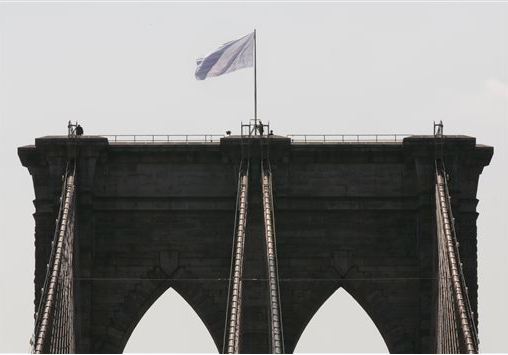 Two white flags fly high atop the Brooklyn Bridge on July 22. AP photo