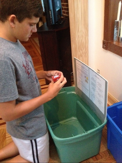 Basil Capetanakis prepares the collection bins he placed at various locations in Bay Ridge to gather toys, puzzles, school supplies and donations for Thursday’s Child, a program that helps autistic children. The donation drive is the centerpiece of Basil’s Eagle Scout project.