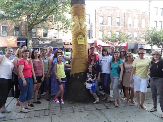 Volunteers “yarn bombed” a tree on Fifth Avenue with gold yarn on Sept. 7 to raise awareness of the plight of children with cancer.