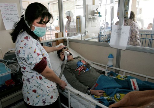 A nurse comforts a sick child. AP photo