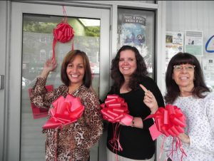 Community Board 10 shows its support for the Red Ribbon Campaign. Community Coordinator Dorothy Garuccio (left), District Manager Josephine Beckmann (center) and Community Assistant JoAnn DelPin placed a ribbon on their office door and plan to decorate trees on Fifth Avenue.