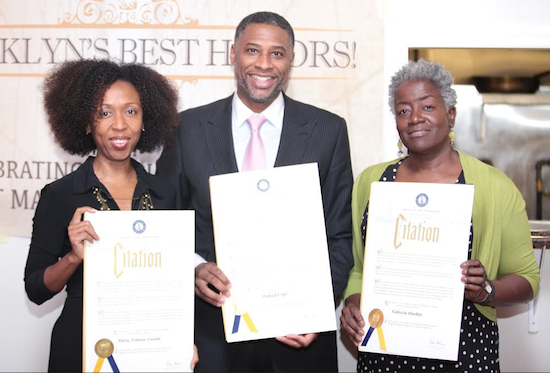 The honorees from left: Community2Community CEO Marie Yolaine Eusebe; Businessman Waleed Cope; and artist Fedrecia Hartley.  The honorees are shown displaying their proclamations for Borough President Eric Adams.