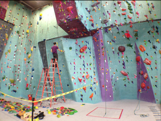 A staffer referred to as a “route setter” changes the climbing routes on the walls at Brooklyn Boulders in Gowanus.