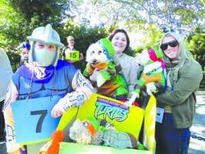Frank Tarsnane, Ursula Nigrelli and Noelle Fonak (left to right) dressed their dogs up as Teenage Mutant Ninja Turtles and won the top prize, “Best in Show.”