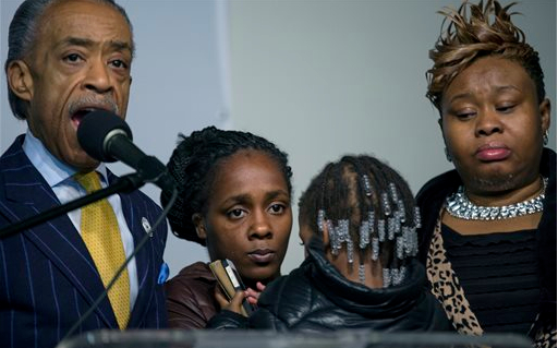 Kimberly Michelle Ballinger, domestic partner of Akai Gurley, center left, who was shot by an NYPD officer is joined by Rev. Al Sharpton, left, Gurley's daughter Akaila Gurley, 2, and and relative Janice Davis-Asiedu at the National Action Network in New York on Saturday. AP Photo/Craig Ruttle