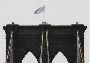 Two white flags flew high atop the Brooklyn Bridge on July 22 and another tourist was arrested on Sunday for trying to scale the bridge. AP photo