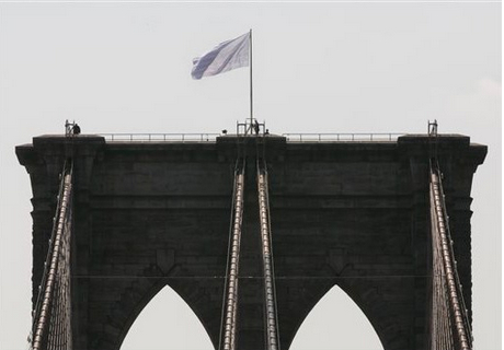 Two white flags flew high atop the Brooklyn Bridge on July 22 and another tourist was arrested on Sunday for trying to scale the bridge. AP photo