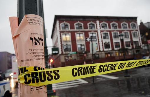 Crime scene tape is wrapped around a pole in front of Chabad-Lubavitch Hasidic headquarters early Tuesday. A knife-wielding man stabbed an Israeli student inside the Brooklyn synagogue before being fatally shot by police after he refused to drop the knife. The student, Levi Rosenblatt, is in stable condition. AP Photo/Mark Lennihan