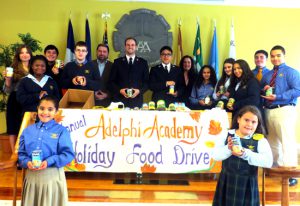 Lt. Joel Ashcroft (center) and Austin Chung of the Bay Ridge Salvation Army Corps were presented with dozens of canned goods donated by Adelphi Academy of Brooklyn students as part of the academy’s annual holiday food drive. Also pictured are Adelphi’s Academic Coordinator/Guidance Counselor Patrizia Vicino, Director of Academy Operations Albert C. Corhan and Head of School Iphigenia Romanos (left to right).