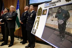 New York City Police Commissioner Bill Bratton, second from left, looks at a video frame of Ismaaiyl Brinsley during a news conference at police headquarters on Monday. Police are asking for the public's help in identifying his whereabouts before he killed two police officers and himself on Saturday afternoon. AP Photo/Seth Wenig
