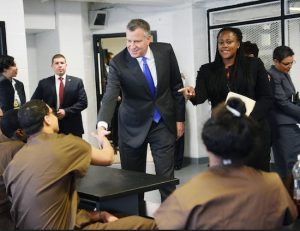 New York City Mayor Bill de Blasio shakes hands with juvenile inmates as Acting Deputy Commissioner of Youthful Offenders, Adult Programming and Community Partnerships Winette Saunders-Halyard, looks on, during a tour at Second Chance Housing on Rikers Island on Wednesday in New York. The facility serves as alternative housing for incarcerated adolescents. AP Photo/The Daily News, Susan Watts, Pool