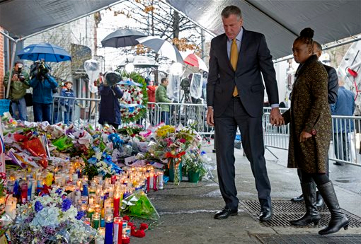 New York City Mayor Bill de Blasio and his wife, Chirlane McCray, visit a makeshift memorial on Tuesday near the site where New York Police Department officers Rafael Ramos and Wenjian Liu were murdered in the Bed-Stuy. Police say Ismaaiyl Brinsley ambushed the two officers in their patrol car in broad daylight Saturday, fatally shooting them before killing himself inside a subway station. AP Photo/Craig Ruttle