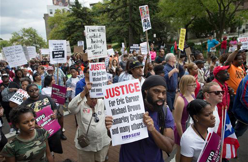 Demonstrators march to protest the death of Eric Garner on Aug. 23 on Staten Island. Amid the fallout from a grand jury's decision in the fatal police shooting of Michael Brown in Missouri, a panel in New York City is nearing its own conclusion about another combustible case involving the death of an unarmed man at the hands of a police officer. AP Photo/John Minchillo, File