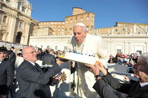 In this photo provided by Vatican newspaper L'Osservatore Romano, Pope Francis blows candles on a cake during his weekly general audience in St. Peter's Square at the Vatican, Wednesday, Dec. 17, 2014. Pope Francis got a cake, cards and a tango demonstration for his 78th birthday Wednesday, and 800 kilograms of chicken meat for the poor. AP Photo/L'Osservatore Romano