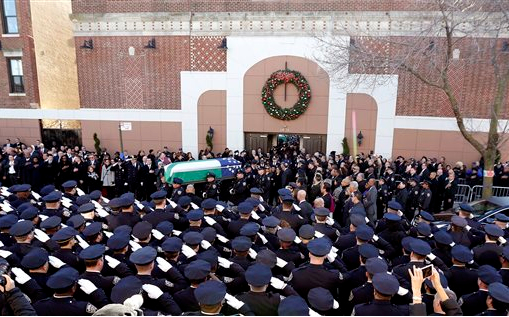 Thousands gathered to mourn the loss of Rafael Ramos in Queens on Saturday. The two slain officers will have their streets they lived on named after them. AP Photo/Julio Cortez