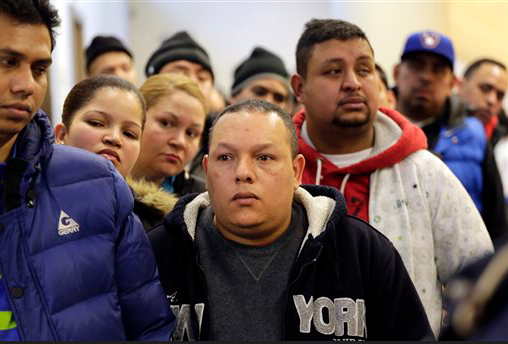 People wait in line to apply for municipal identification cards on the first day they are available at the Bronx Library Center on Monday in New York. The card, dubbed IDNYC, is aimed at those who don't currently have an ID. That includes the elderly, homeless and an estimated 500,000 immigrants in the city who live in the U.S. without legal documentation. The cards will be mailed to the recipients in three weeks. AP Photo/Mark Lennihan