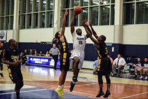 Michael Megafu (15 in white) scored 24 points, including 18 in the second half, and had 10 rebounds to pick up his 10th double-double of the season in St. Joseph’s win over Medgar Evers College. Photo by Rob Abruzzese.