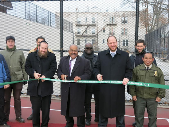 Brooklyn Parks Commissioner Kevin Jeffrey (center) helps cut the ribbon to open new basketball and handball courts at Colonel David Marcus Playground. At right is Councilmember David Greenfield. Community Board 12 Chairman Yidel Perlstein is at left. Photo courtesy Greenfield’s office