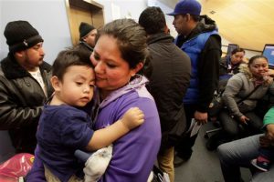 Veronica Ramirez, originally from Mexico, holds her 15-month-old son, Lora, as she waits in line to apply for a municipal identification card on the first day they are available at the Bronx Library Centeron Monday. The card, dubbed IDNYC, is aimed at those who don't currently have an ID. AP Photo/Mark Lennihan