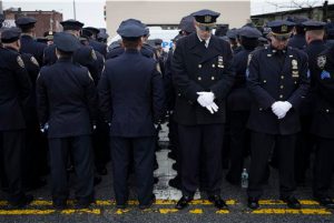 Some police officers, left, turn their backs in a sign of disrespect as Mayor Bill de Blasio speaks as others, at right front line, stand at attention, during the funeral of New York Police Department Officer Wenjian Liu at Aievoli Funeral Home on Sunday in Brooklyn. AP Photo/John Minchillo