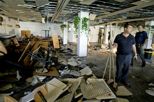 In this 2002, file photo, workers clean the inside of a cafeteria hours after a bomb exploded at Hebrew University in Jerusalem, killing nine, four of them Americans, and wounding more than 70. Terrorism victims are suing the Palestinian Liberation Organization and the Palestinian Authority in New York for damages under the Anti-Terrorism Act. AP Photo/David Guttenfelder, File