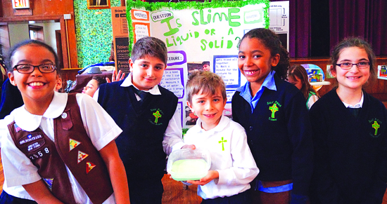 Anthony Villamagna (second from left) drew a large crowd of students to his table at the St. Patrick Catholic Academy Science Fair. The excited youngsters couldn’t wait to touch the slime he studied as part of his project, titled “Is Slime a Liquid or a Solid?”