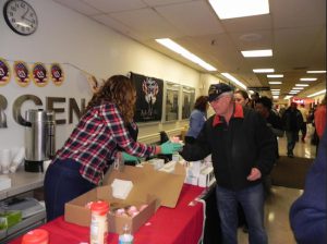 A volunteer from the organization Soldiers’ Angels helps distribute cupcakes to veterans at the V.A. hospital in Bay Ridge on Tuesday. Eagle photo by Paula Katinas