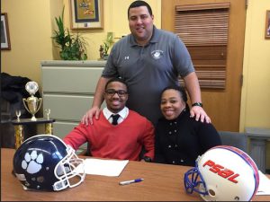 Fort Hamilton Tigers football player Michael Brooks, lower left, with Coach Danny Perez, top, and Brooks’ mother. Photo courtesy of Fort Hamilton High School Athletic Department