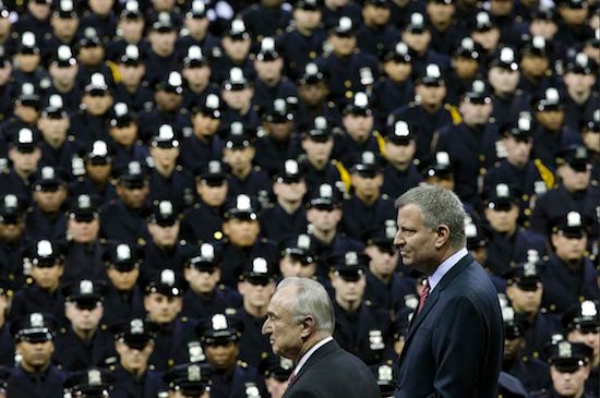 In this December 2014 file photo, Mayor Bill de Blasio, right, and NYPD Police Commissioner Bill Bratton, center, stand on stage during a New York Police Academy graduation ceremony at Madison Square Garden. After months of friction between the NYPD’s sergeants union and de Blasio, the union is signing a new labor contract with City Hall. AP Photo/John Minchillo