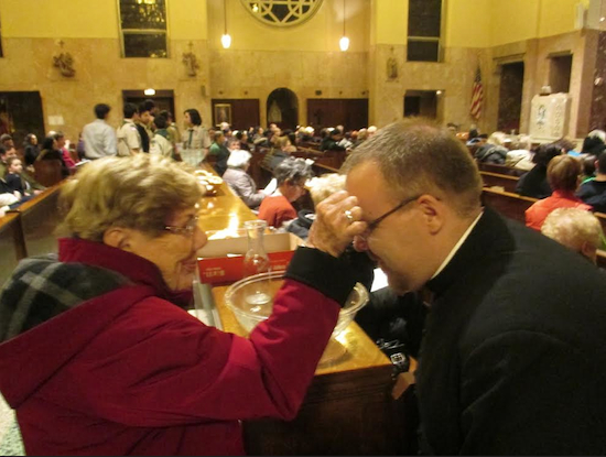 Ann Kelly, a parishioner of Saint Anselm Church, and the Rev. Stephen Saffron take the opportunity to bless one another during a parish’s recent Lenten Mission. Photo courtesy St. Anselm Publicity Committee