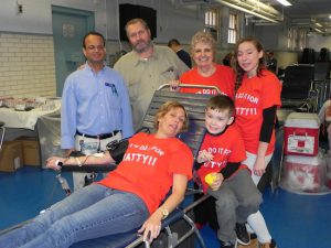 Christine Maxwell, sister of the late Mathiew Johnson, donates blood in her brother’s memory and receives encouragement from Mohammed Rahman, of the New York Blood Center, her dad Doug Johnson, her mother, June Johnson, and her children, Julia and Richard Maxwell. Eagle photos by Paula Katinas