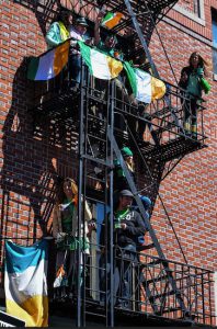 People gathered along Third Avenue in Bay Ridge to check out the St. Patrick’s Day Parade. Some even found good views from their fire escapes.​ Eagle photo by Rob Abruzzese. For more photos, go to brooklynarchive.com.