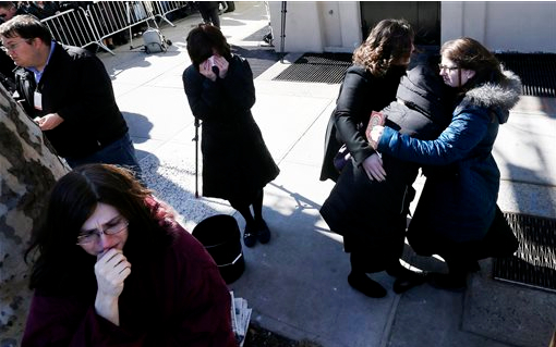 A woman is consoled as others cry as vehicles carrying the remains of the seven siblings killed in a house fire depart after funeral services, Sunday in Brooklyn. The siblings, ages 5 to 16, died early Saturday when flames engulfed the Sassoon family home in Midwood. Investigators believe a hot plate left on a kitchen counter set off the fire that trapped the children. AP Photo/Julio Cortez