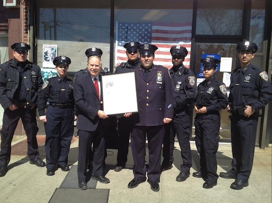 State Assemblyman Bill Colton presents a citation to P.O. Albert Mammon as auxiliary officers from the 60th Precinct look on. Photo courtesy Colton’s office